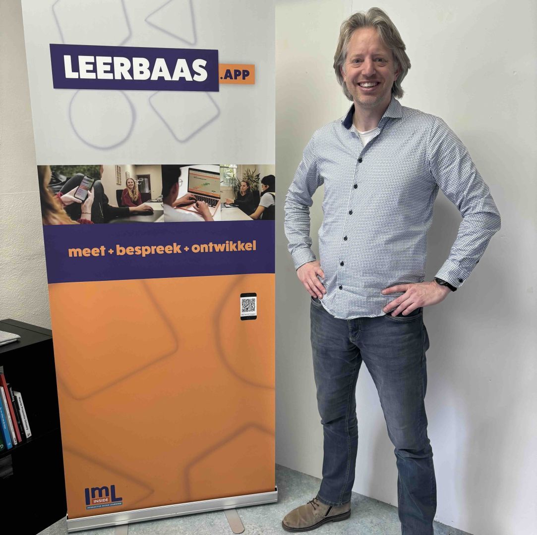 Trotse eigenaar poseert voor de banner van Leerbaas.app
